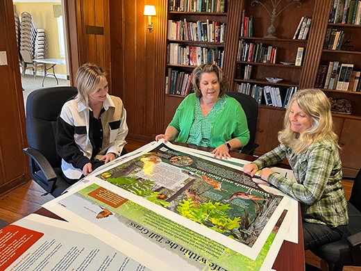 Forest Preserve of Kane County Staff review the final proofs of the new interpretive trail signage for LeRoy Oakes Forest Preserve at Creek Bend Nature Center.